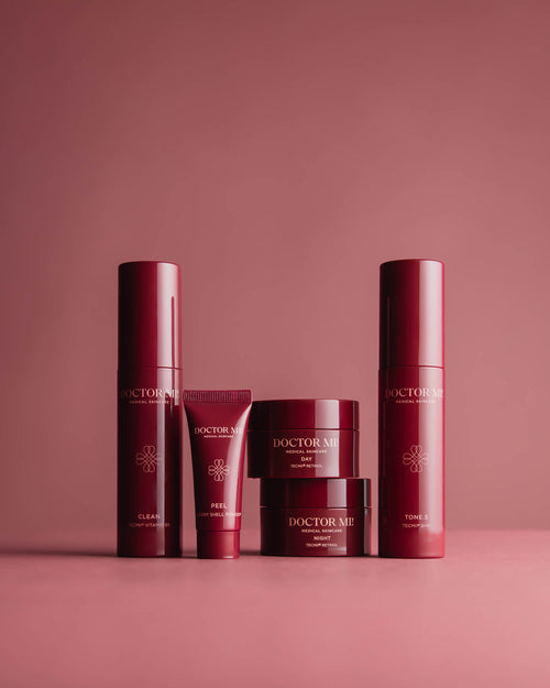 DOCTOR MI! DISCOVER MI! SET Produktset als Einstieg in die Retinolpflege, ideal zum Ausprobieren oder für Unterwegs mit BALANCING CLEANSER in rotem Pumpspender, REVIVING PEEL in roter Tube, RENEWING TONER in rotem Pumpspender, REFINING DAY CREAM in rotem Tiegel, REGENERATING NIGHT CREAM in rotem Tiegel auf rotem Hintergrund