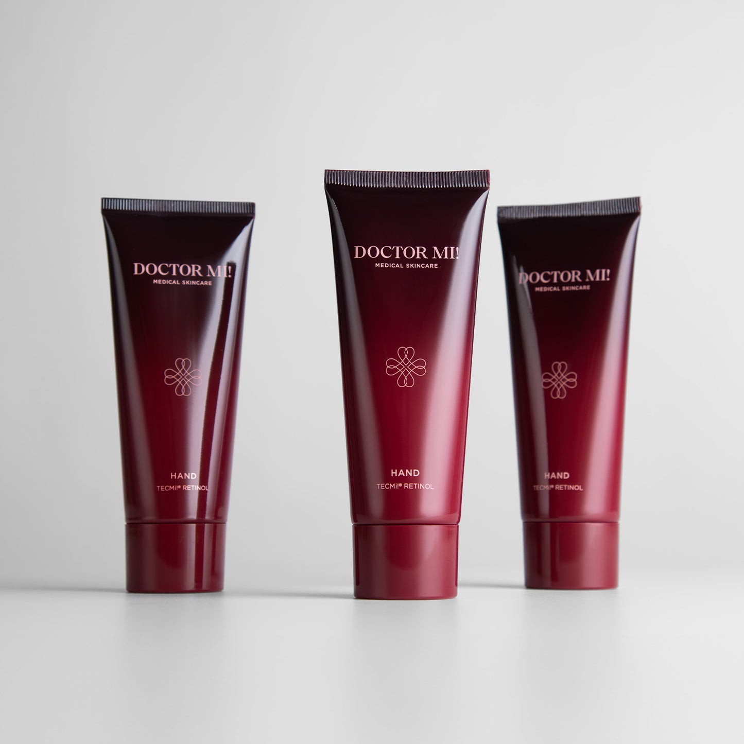 DOCTOR MI! RENEWING HAND CREAM pflegende Handcreme mit Retinol TECMi!® Technologie in roter Tube auf grauem Hintergrund