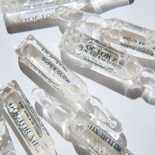 DOCTOR MI! SUPER GLOW AMPOULES kraftvolle Pflegekur für intensiven Glow Boost und einen frischen, strahlenden Teint in Glasampullen Verpackung auf weißem Hintergrund