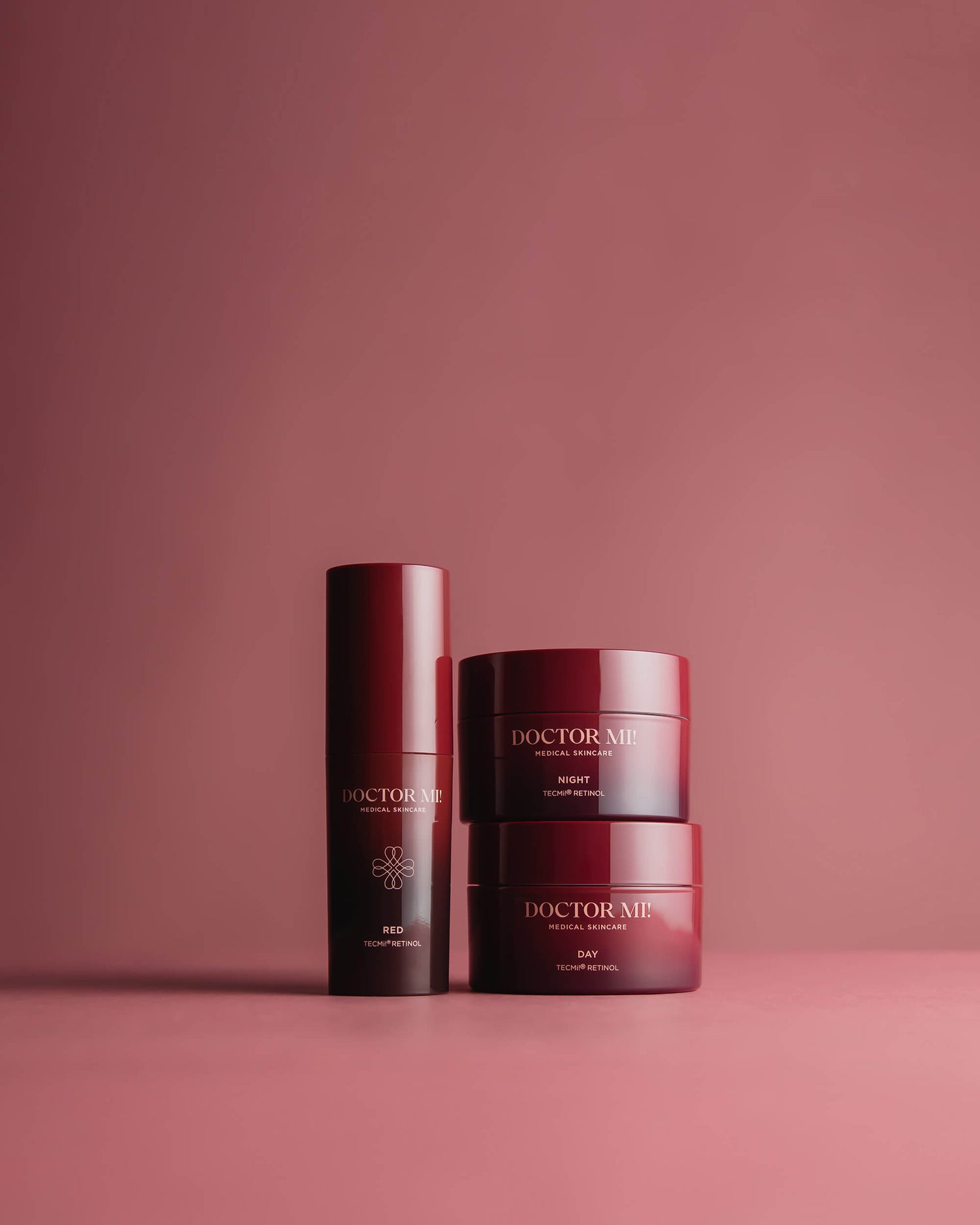 DOCTOR MI! RETINOL BEGINNER SET wirkungsvoller Einstieg in die Retinolpflege mit aufeinander aufgebauten TECMi!® Retinol-Konzentrationen mit REFINING DAY CREAM in rotem Tiegel, REGENERATING NIGHT CREAM in rotem Tiegel, RED BOOSTER in rotem Pumpspender auf rotem Hintergrund 